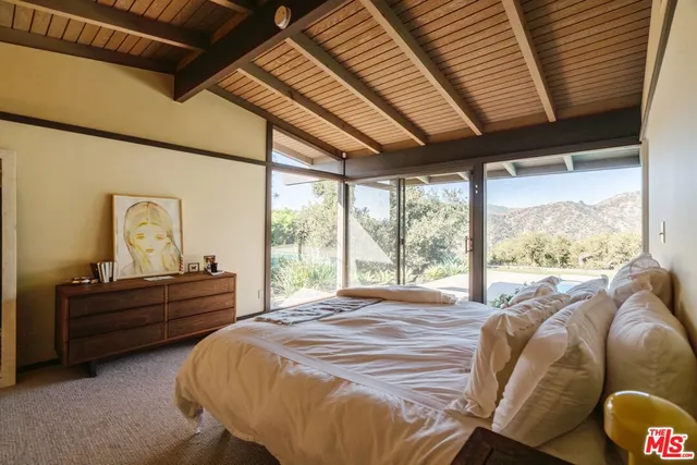 a bed sitting in a bedroom next to a window