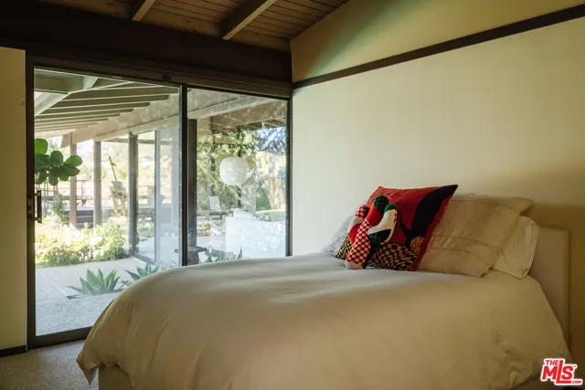 a bed sitting in a bedroom next to a window