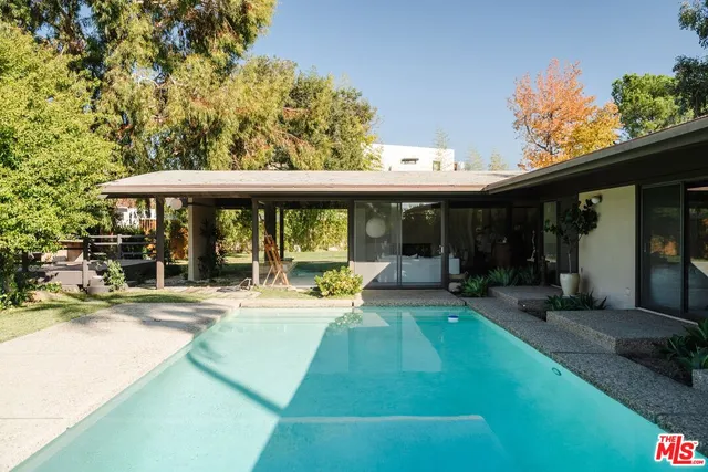 a view of a house with pool and sitting area