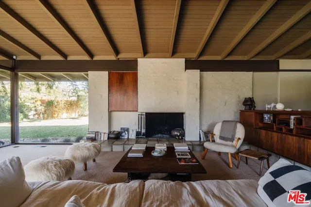 a living room with furniture a fireplace and a floor to ceiling window