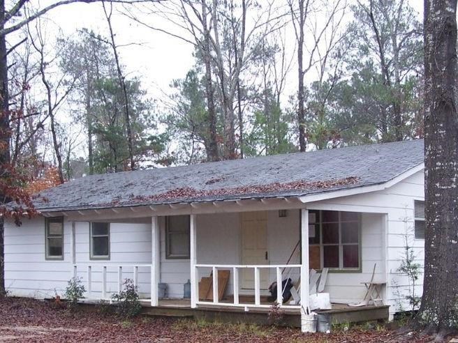 a view of a house with a yard and large tree
