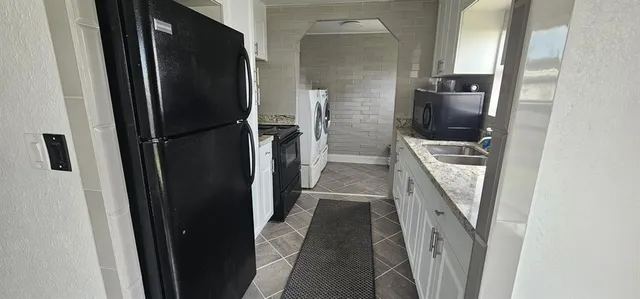 a kitchen with a refrigerator and car parked