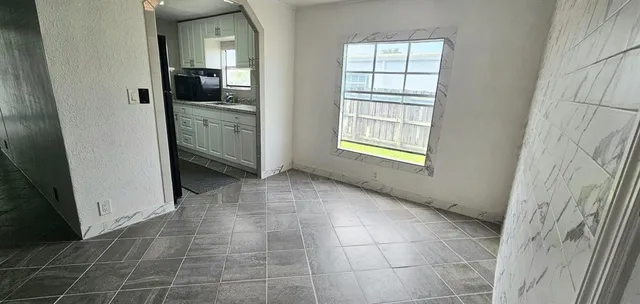 a view of a kitchen in an empty room and window