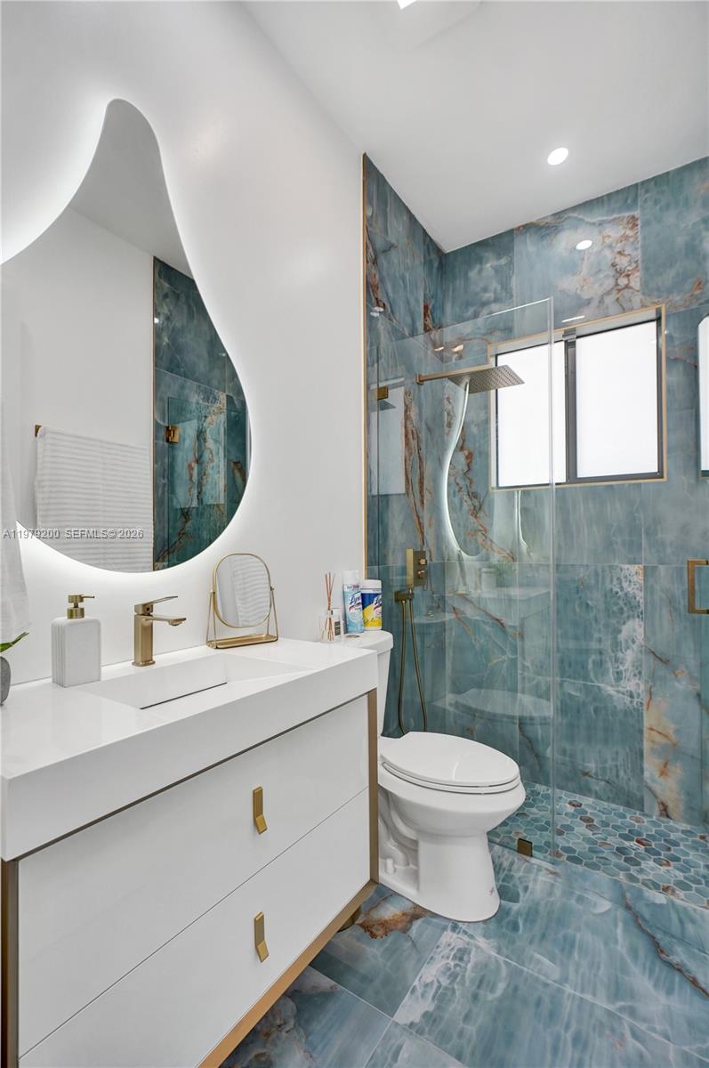 13676 Southwest 33rd Terrace Miami, FL 33175 - Photo 26 of 90 a bathroom with a double vanity sink toilet and a mirror