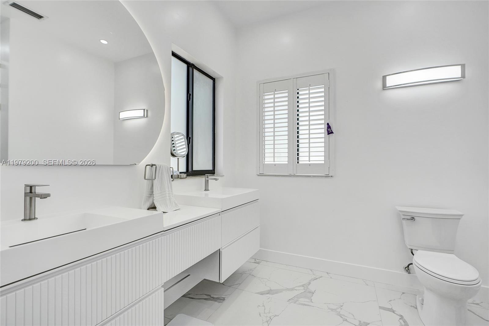 13676 Southwest 33rd Terrace Miami, FL 33175 - Photo 40 of 90 a bathroom with a toilet sink and mirror