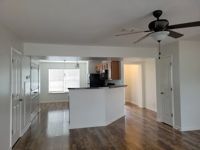 a living room with stainless steel appliances kitchen island hardwood floor and wooden floor