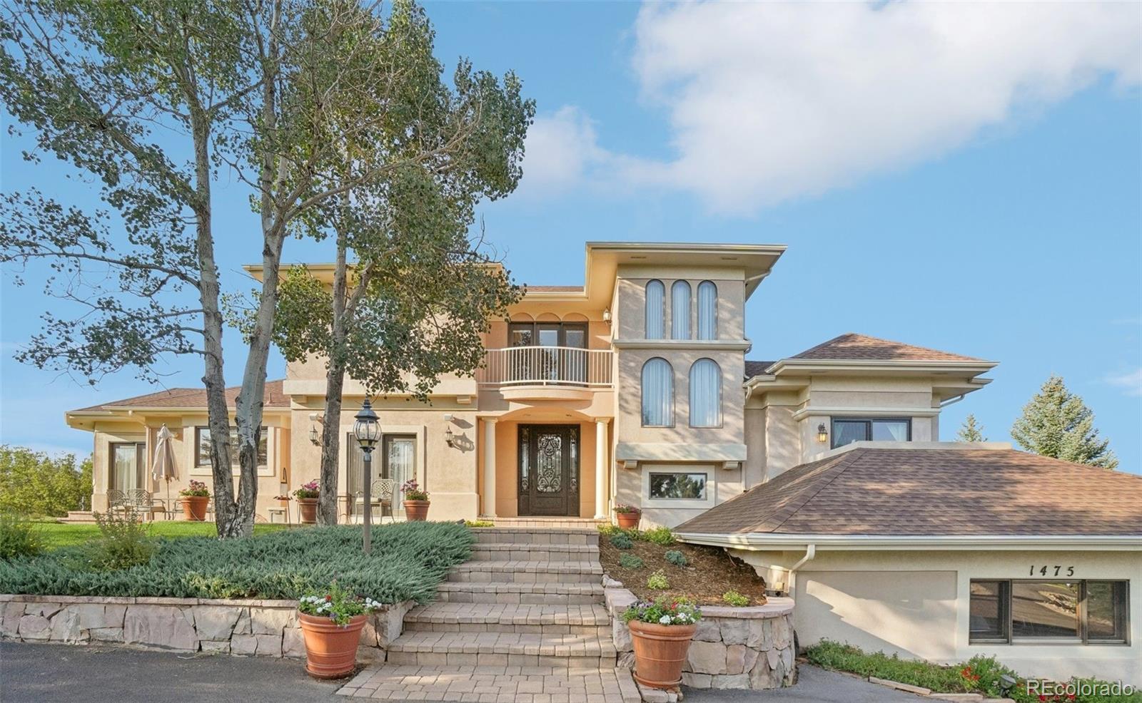 1475 Elk View Road Larkspur, CO 80118 - Photo 1 of 45 a front view of a house with a garden