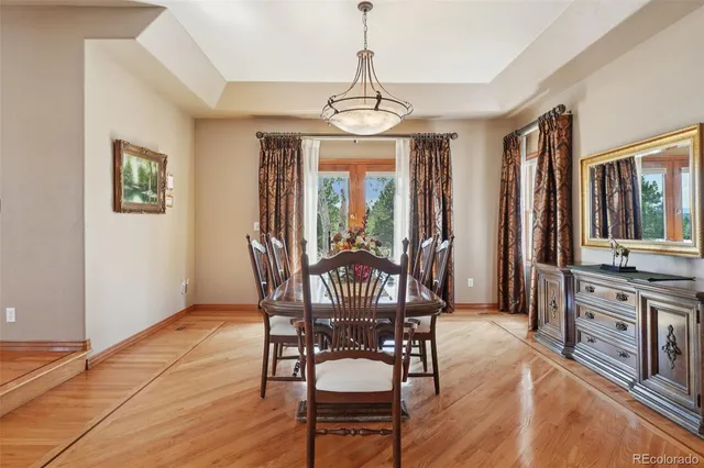 a view of a a dining room with furniture window and wooden floor