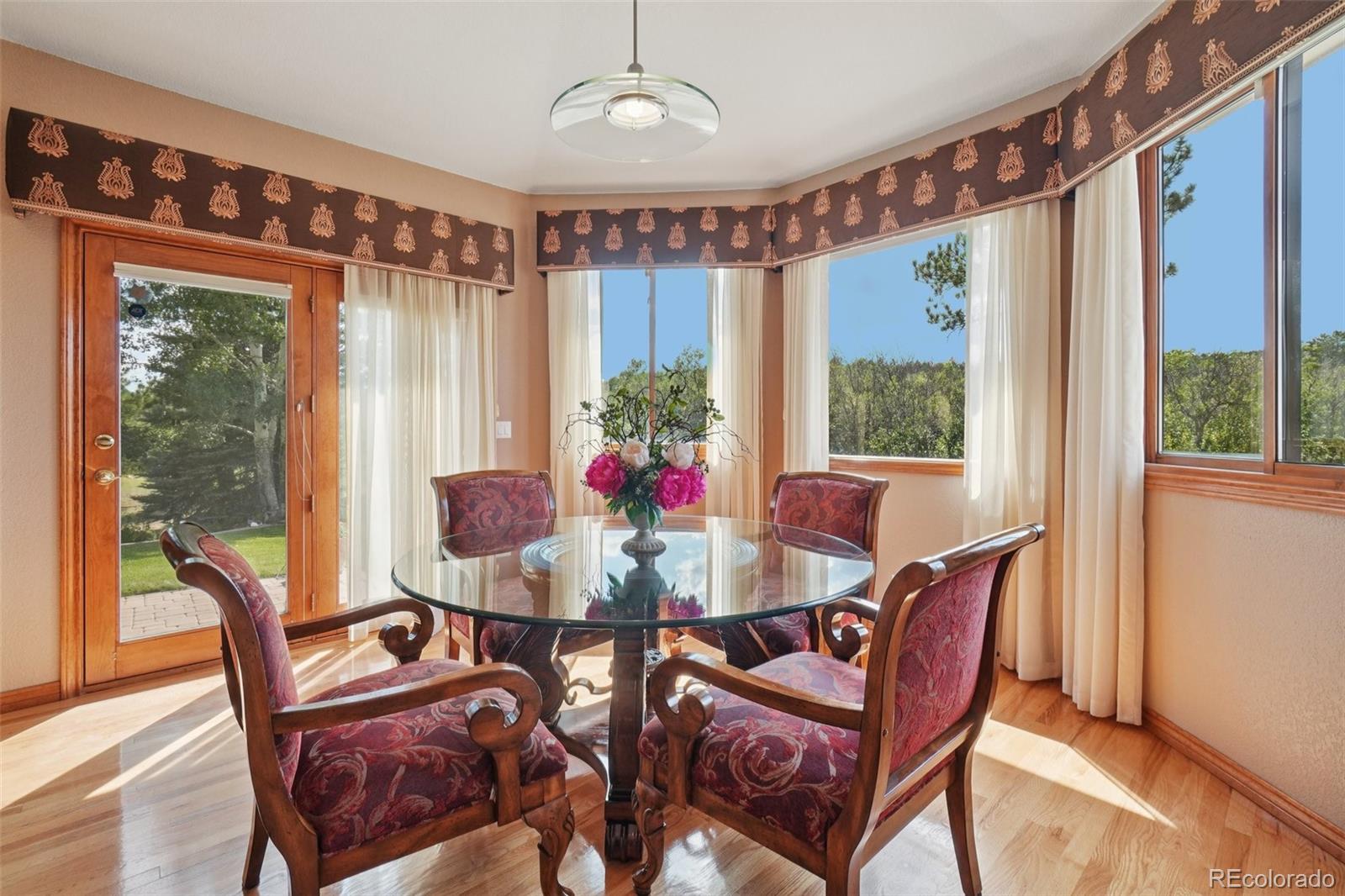 1475 Elk View Road Larkspur, CO 80118 - Photo 12 of 45 a view of a dining room with furniture window and outside view