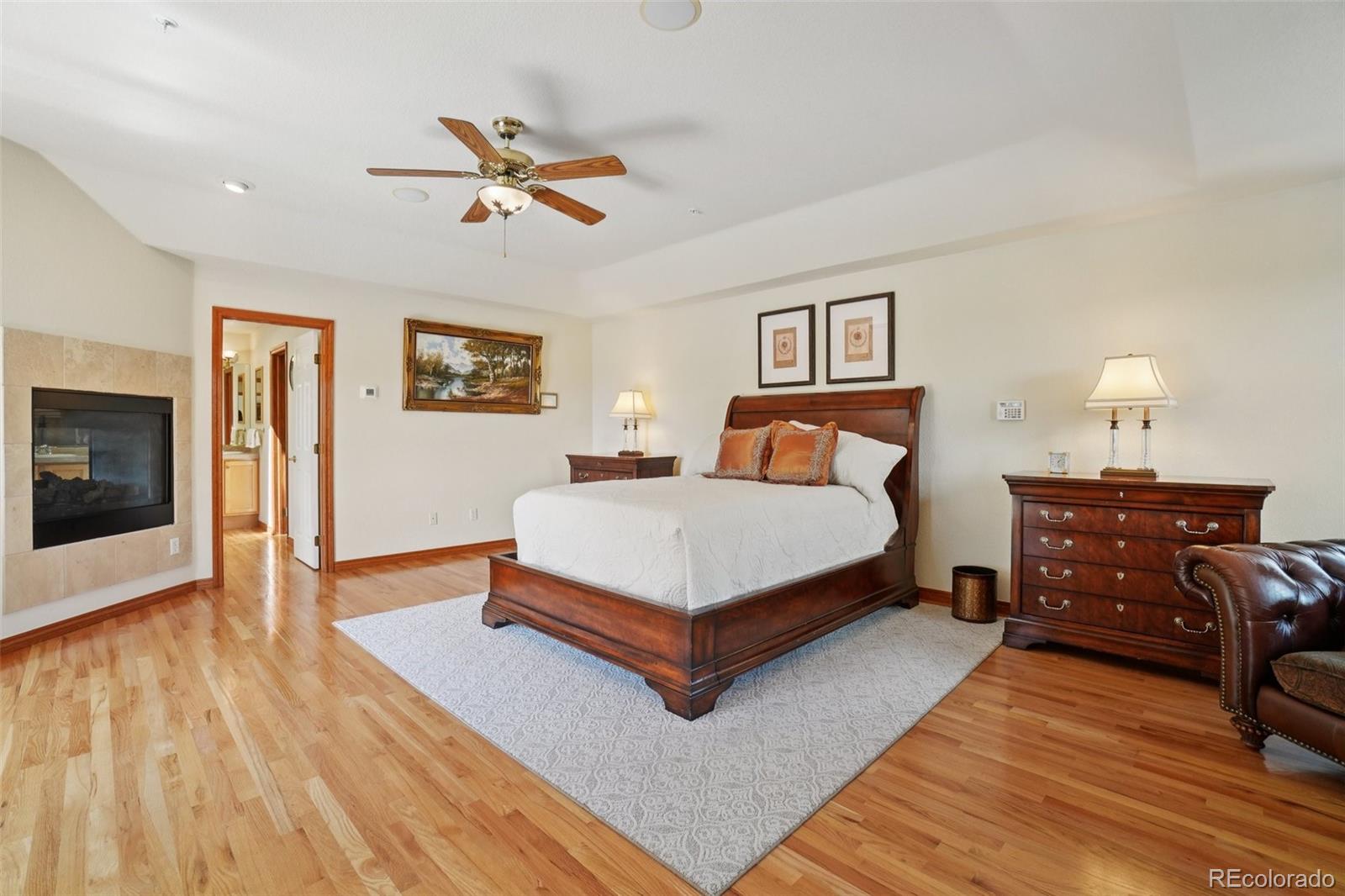 1475 Elk View Road Larkspur, CO 80118 - Photo 16 of 45 a bedroom with a bed and wooden floor