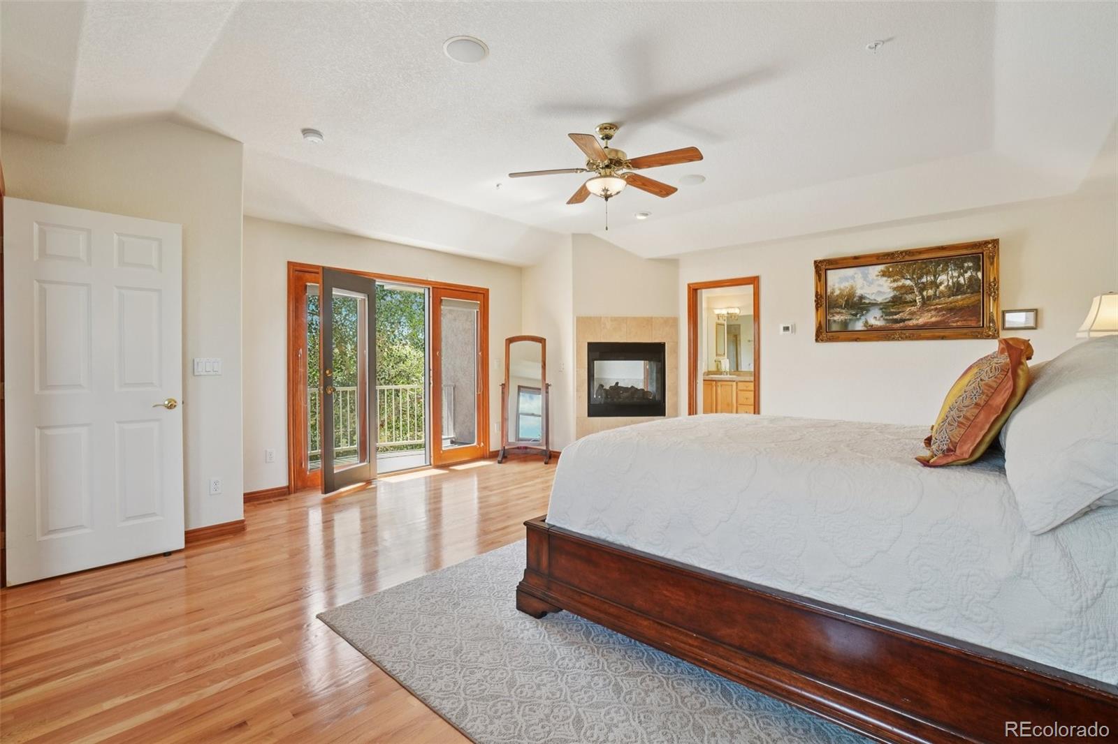 1475 Elk View Road Larkspur, CO 80118 - Photo 17 of 45 a bed room with a bed and a large window