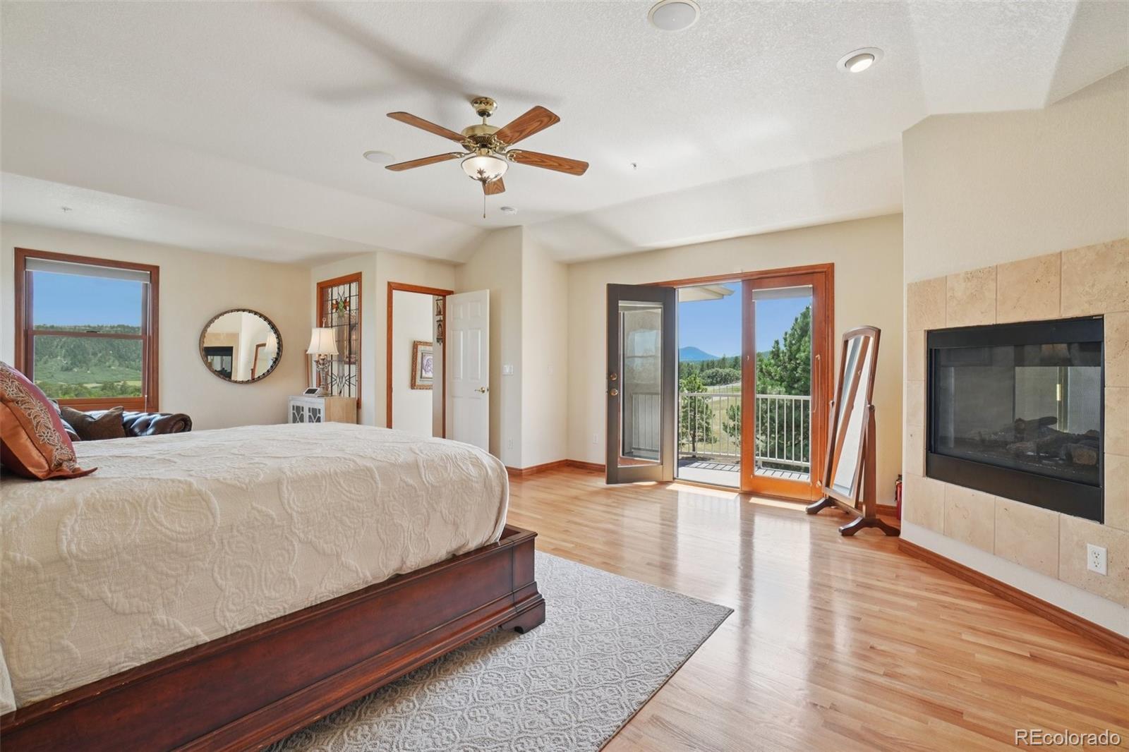 1475 Elk View Road Larkspur, CO 80118 - Photo 18 of 45 a bedroom with a large bed and a large window