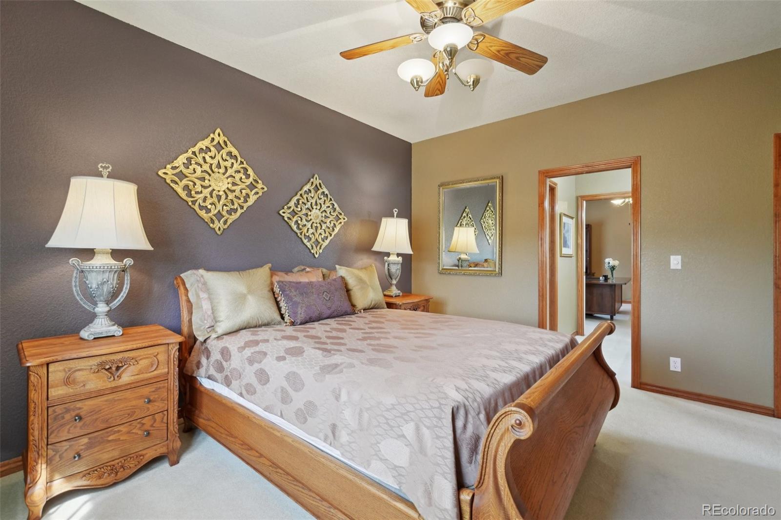 1475 Elk View Road Larkspur, CO 80118 - Photo 25 of 45 a bedroom with a bed and a lamp on table