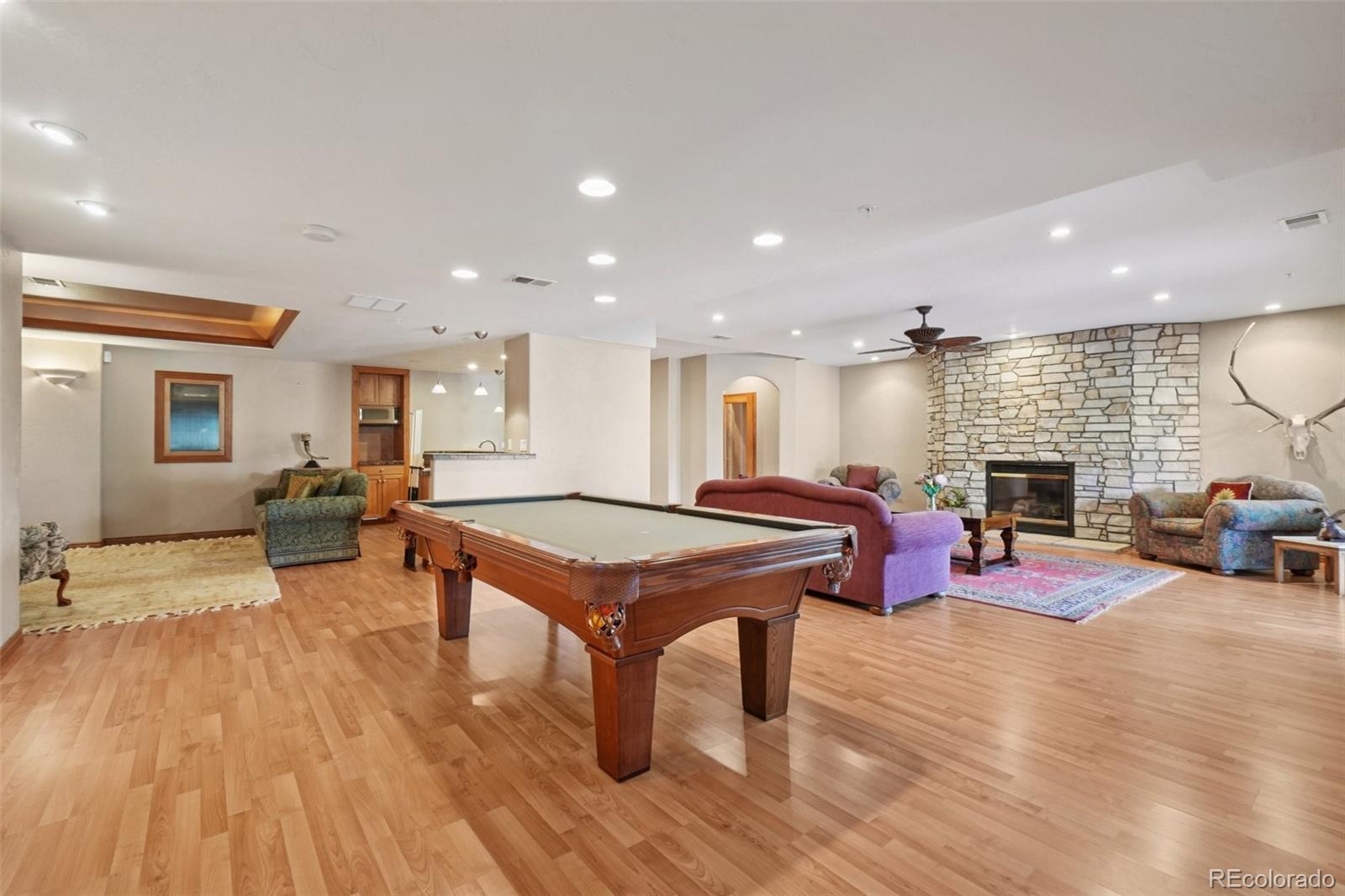 1475 Elk View Road Larkspur, CO 80118 - Photo 26 of 45 a room with lots of furniture and wooden floor