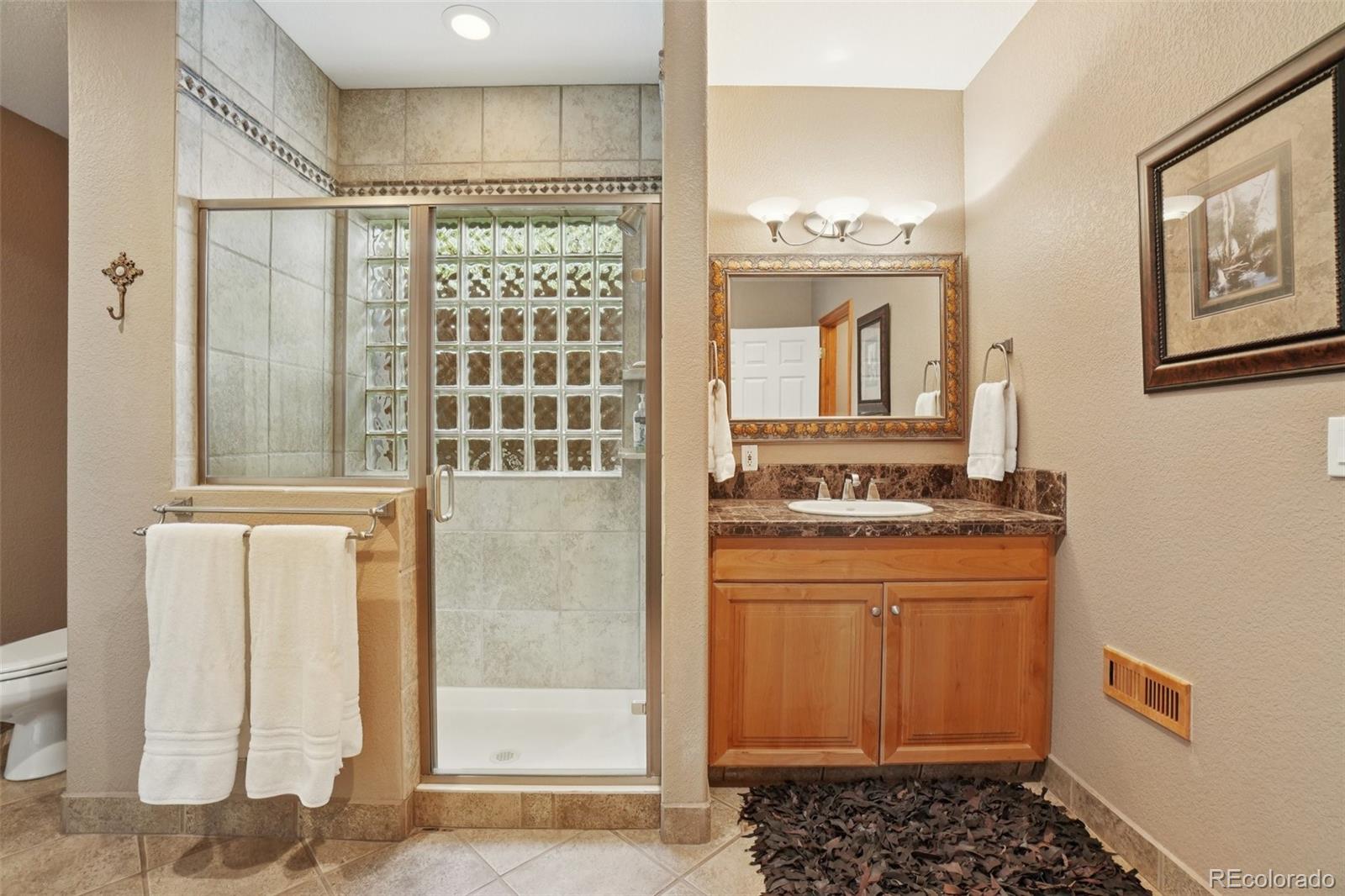1475 Elk View Road Larkspur, CO 80118 - Photo 32 of 45 a bathroom with a sink and a mirror