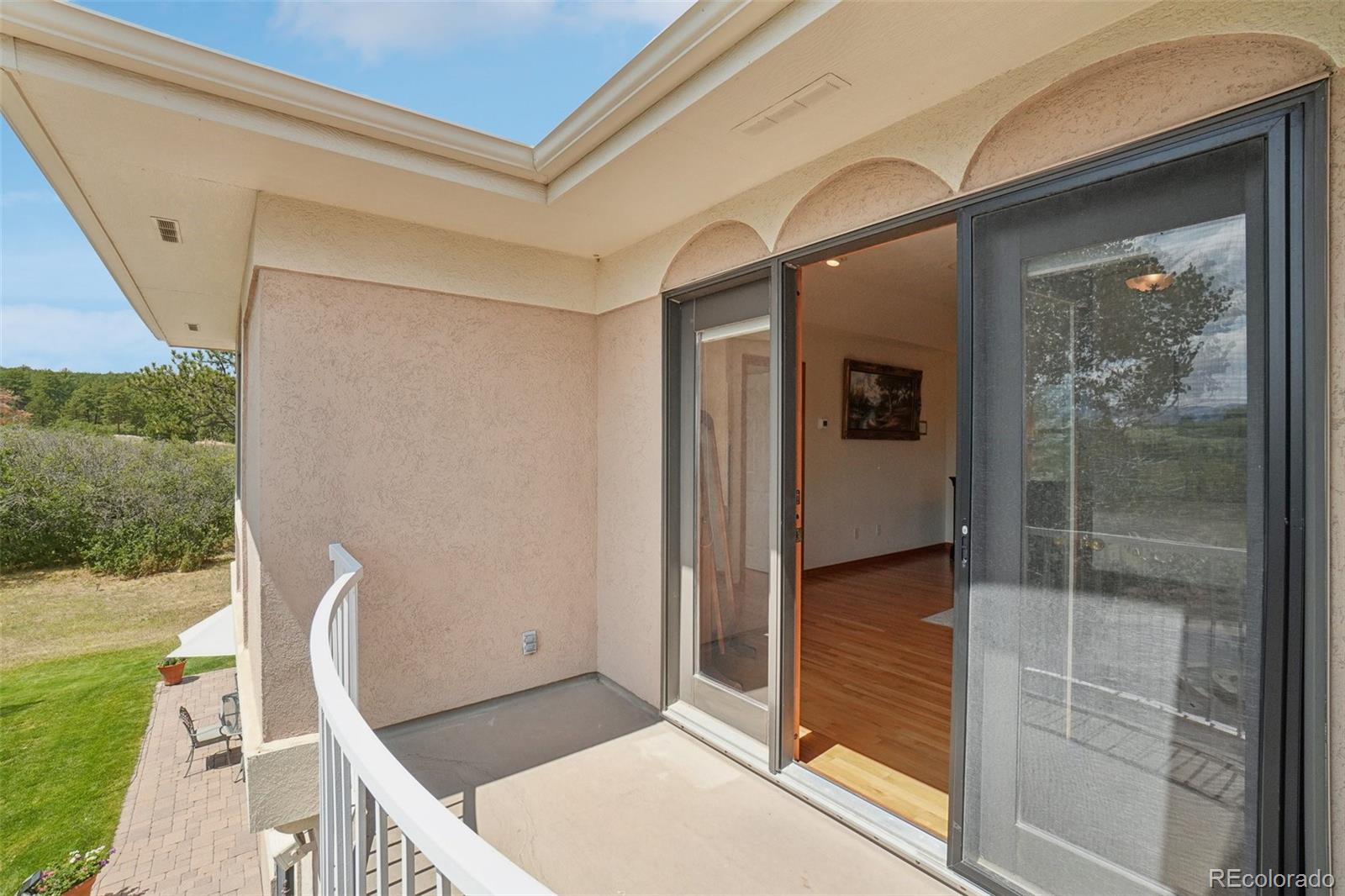 1475 Elk View Road Larkspur, CO 80118 - Photo 33 of 45 a porch with a table and chairs
