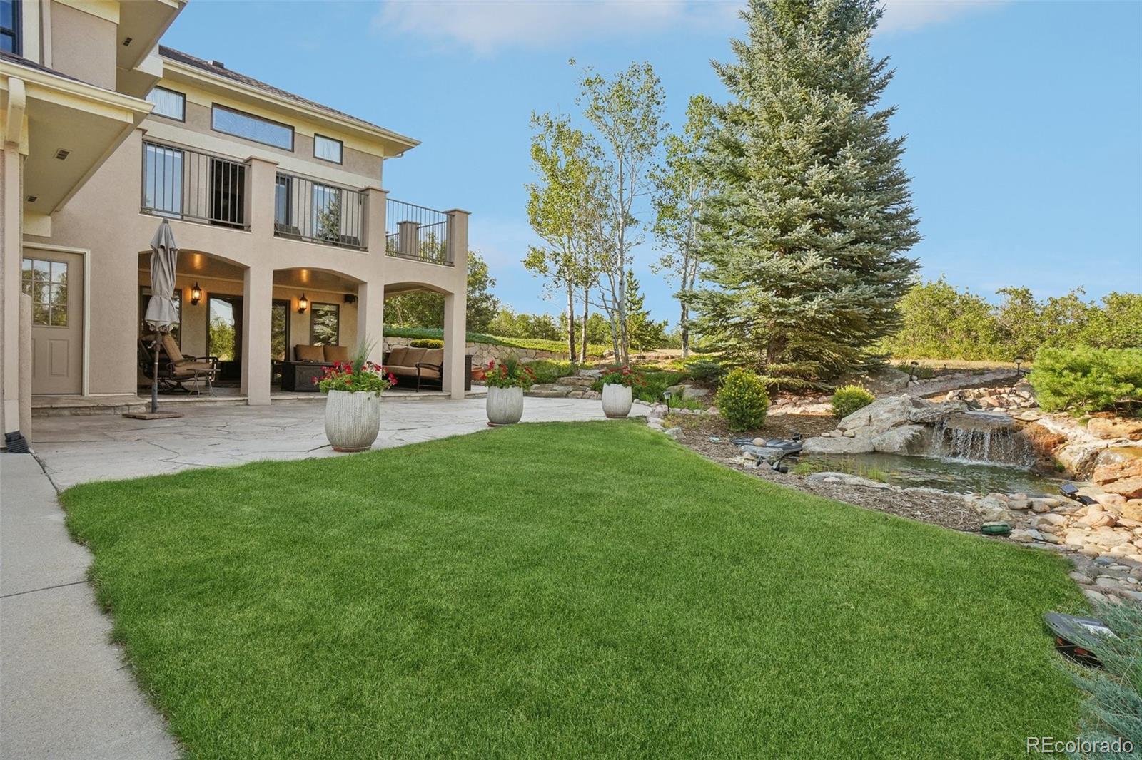 1475 Elk View Road Larkspur, CO 80118 - Photo 4 of 45 a front view of a building with garden