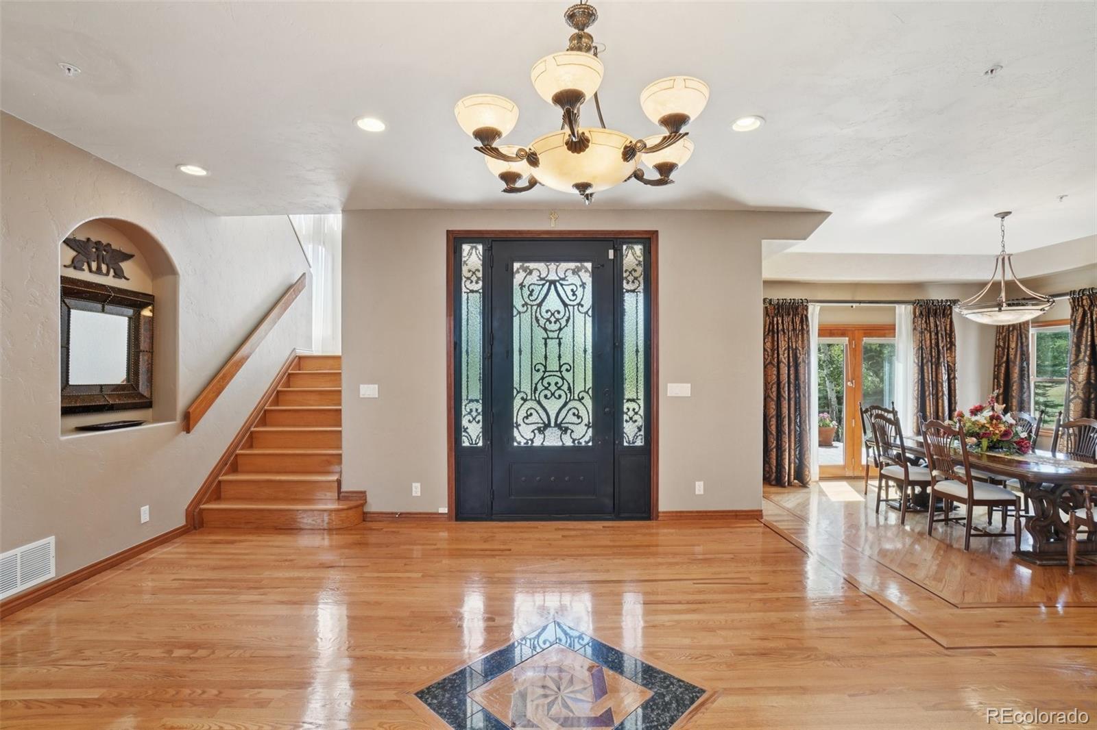 1475 Elk View Road Larkspur, CO 80118 - Photo 5 of 45 a view of a dining room with furniture wooden floor and chandelier