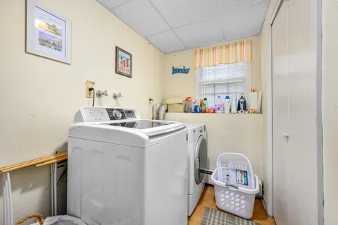 a utility room with dryer washer and a view of living room