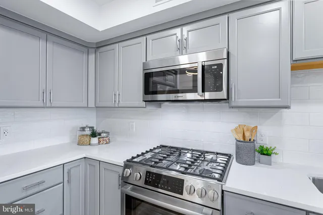 a kitchen with cabinets stainless steel appliances and wooden floor