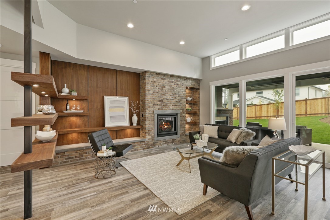 1430 236th Street Southeast Bothell, WA 98021 - Photo 11 of 38 a living room with furniture a fireplace and a floor to ceiling window