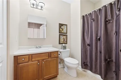 a bathroom with a toilet a sink a vanity and mirror