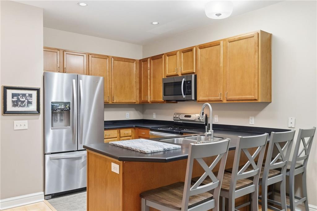 5570 Centre Avenue, Unit 400 Pittsburgh, PA 15232 - Photo 7 of 28 a kitchen with stainless steel appliances granite countertop a refrigerator stove microwave and sink