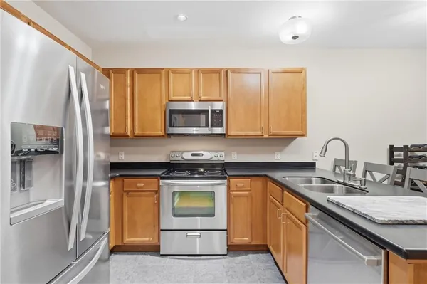 a kitchen with stainless steel appliances granite countertop a stove a sink and a microwave