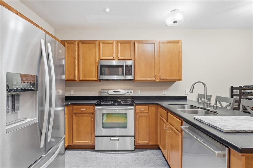 5570 Centre Avenue, Unit 400 Pittsburgh, PA 15232 - Photo 8 of 28 a kitchen with stainless steel appliances granite countertop a stove a sink and a microwave