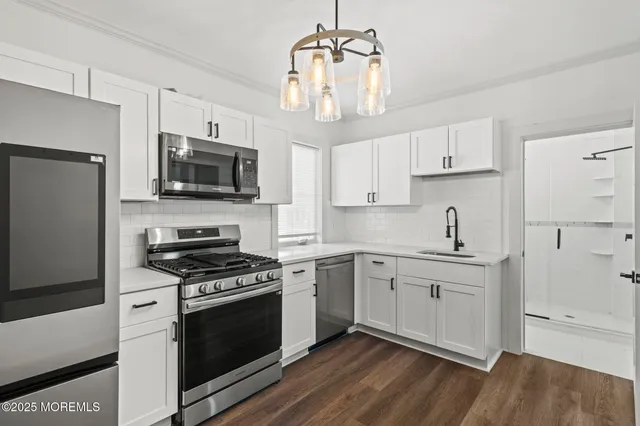 a kitchen with stainless steel appliances a stove a sink and a refrigerator