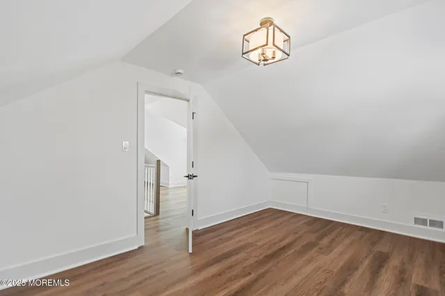 an empty room with wooden floor and ceiling fan
