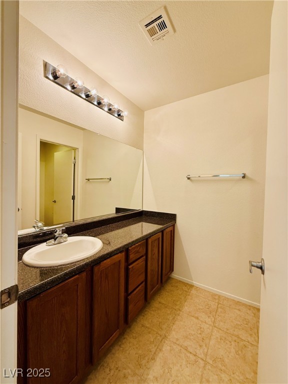 9342 Winebrook Avenue Las Vegas, NV 89148 - Photo 18 of 32 Bathroom featuring vanity, a textured ceiling, and light tile patterned floors