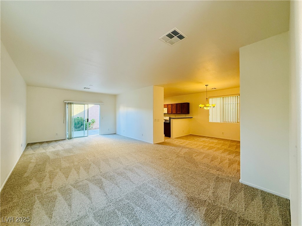9342 Winebrook Avenue Las Vegas, NV 89148 - Photo 5 of 32 Spare room featuring light carpet and a chandelier