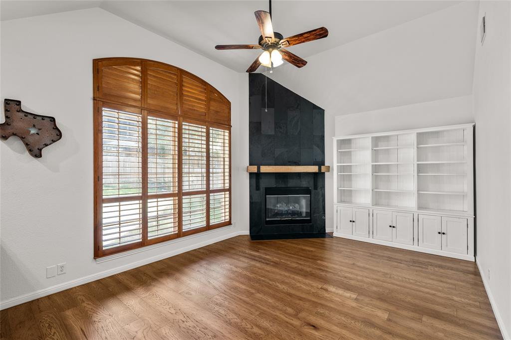 3901 Caney Creek Road Austin, TX 78732 - Photo 4 of 18 Family room has a wall of windows which offer natural light. Corner fireplace. Built-in bookcases afford more storage.