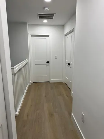 a view of a hallway with wooden floor