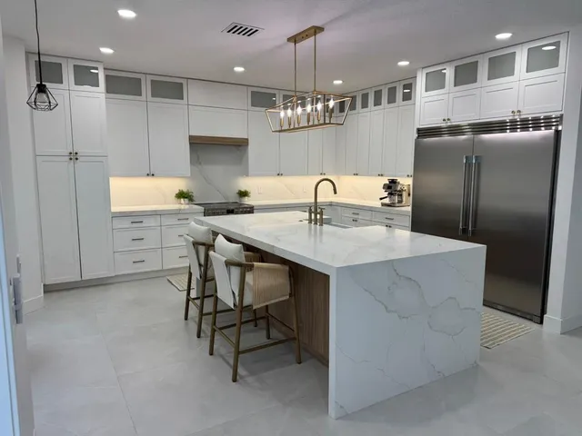 a kitchen with kitchen island a sink stainless steel appliances and cabinets