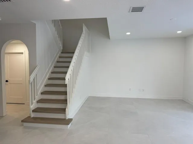 an empty room with stairs and white walls