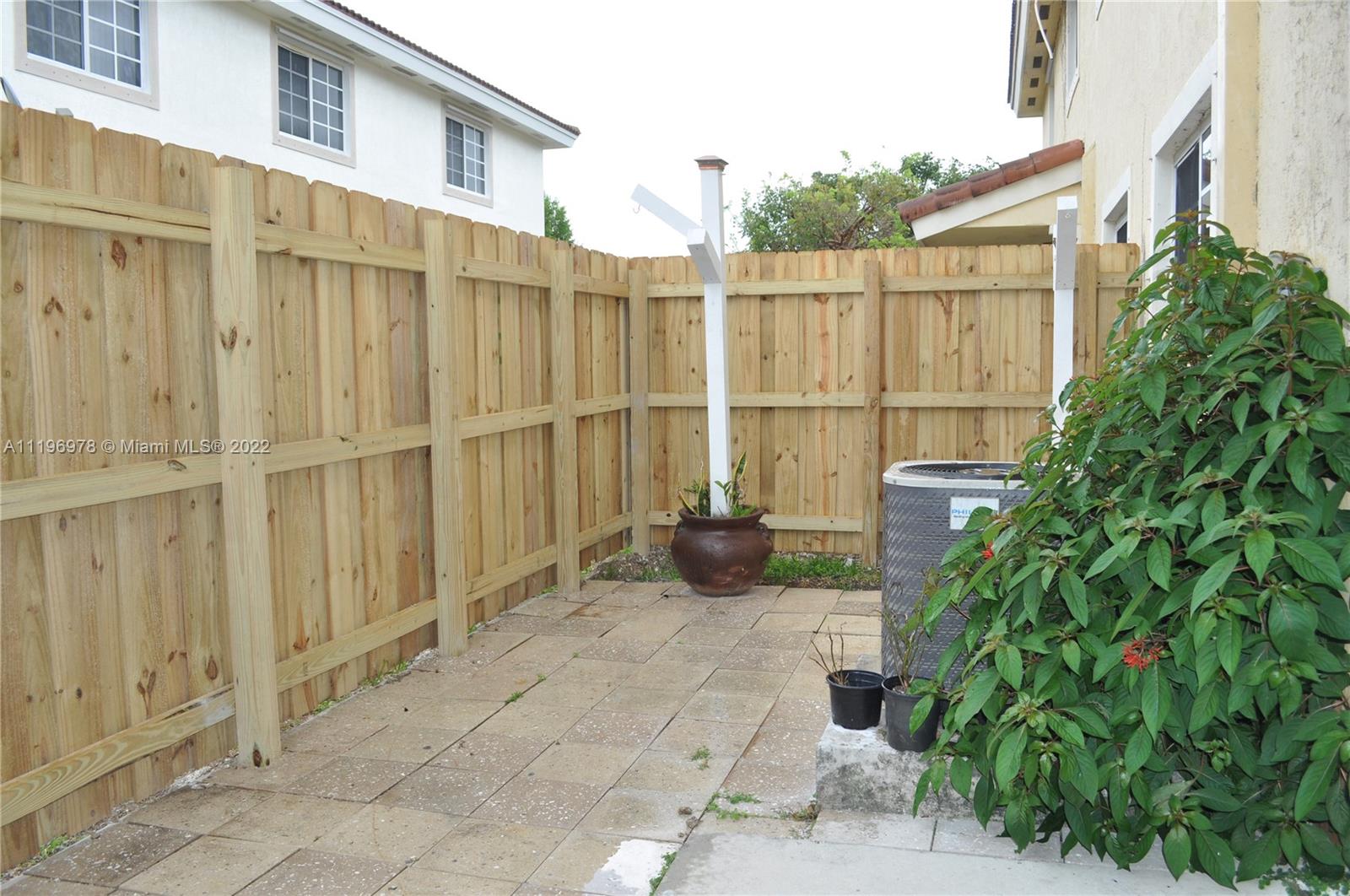 14086 Southwest 260th Street, Unit 106 Homestead, FL 33032 - Photo 12 of 26 a view of a chair and table in the back yard of the house