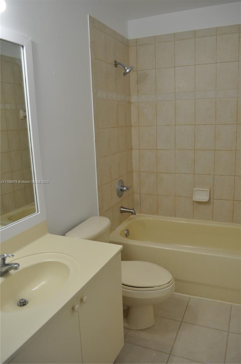 14086 Southwest 260th Street, Unit 106 Homestead, FL 33032 - Photo 15 of 26 a bathroom with a sink a toilet and shower