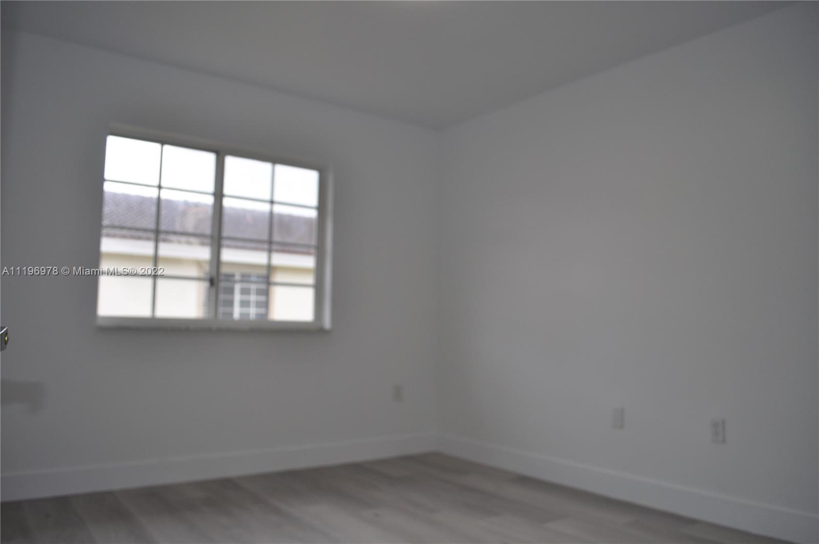 14086 Southwest 260th Street, Unit 106 Homestead, FL 33032 - Photo 18 of 26 an empty room with a window