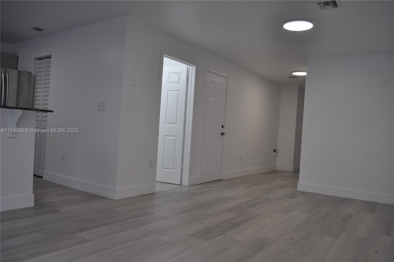 14086 Southwest 260th Street, Unit 106 Homestead, FL 33032 - Photo 4 of 26 wooden floor in an empty room with a window