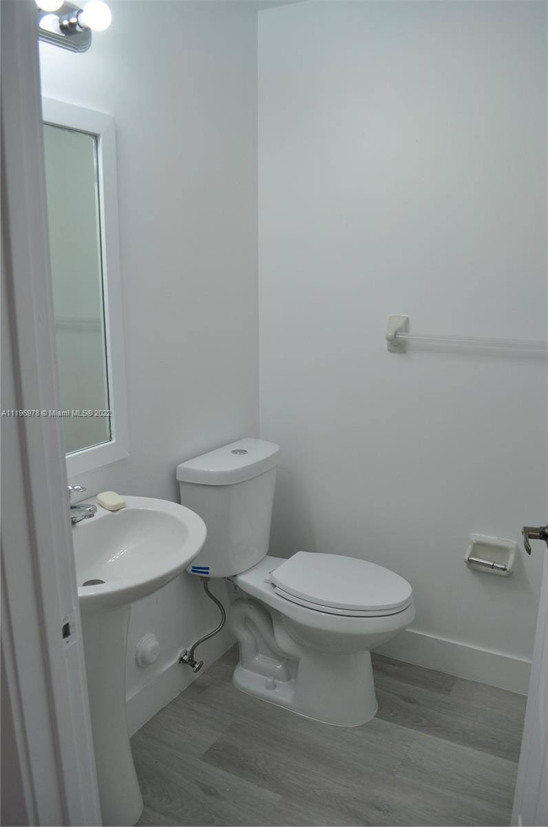 14086 Southwest 260th Street, Unit 106 Homestead, FL 33032 - Photo 6 of 26 a white toilet sitting next to a bathroom sink and vanity