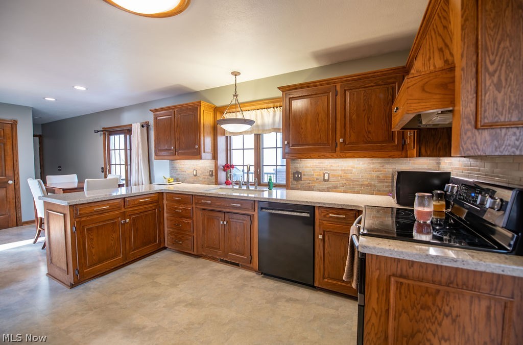 4848 Fette Road Dennison, OH 44621 - Photo 23 of 48 Kitchen with wood finish cabinets, black appliances, a peninsula, light stone countertops, and pendant lighting