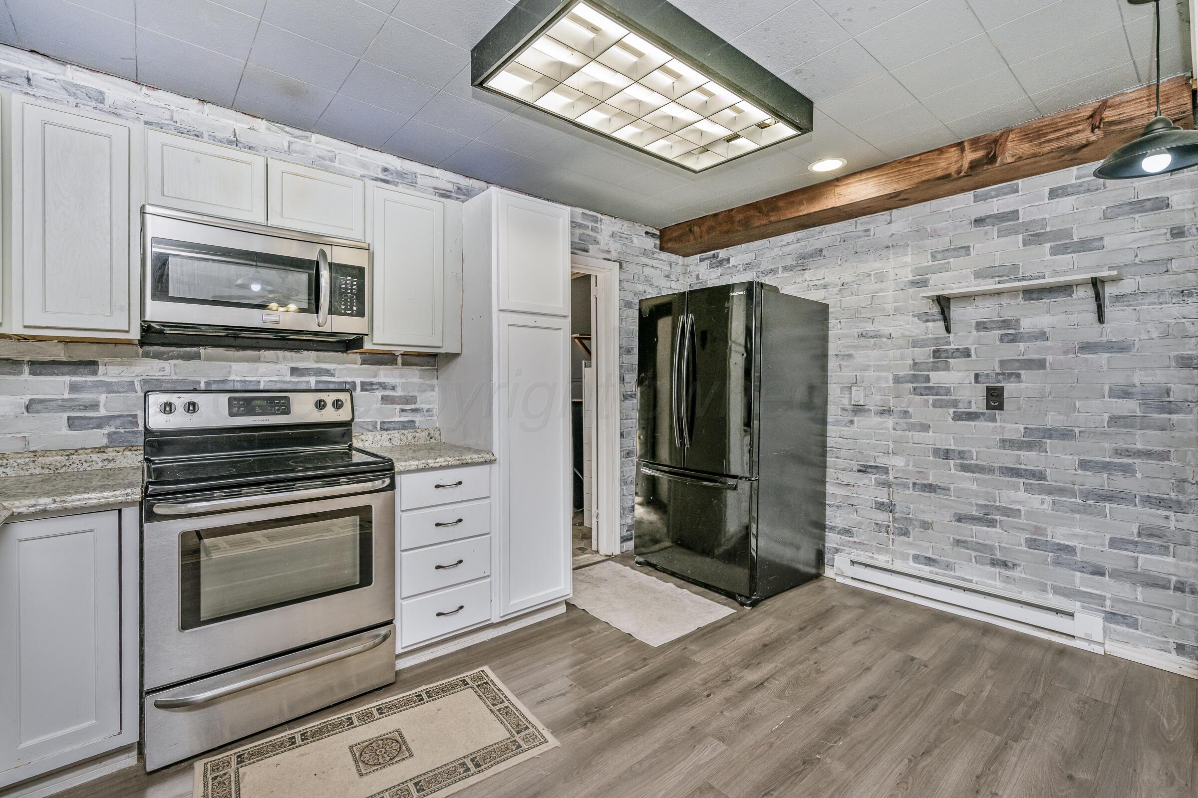 4429 Bowie Street Amarillo, TX 79110 - Photo 7 of 20 a kitchen with stainless steel appliances a stove microwave and a refrigerator