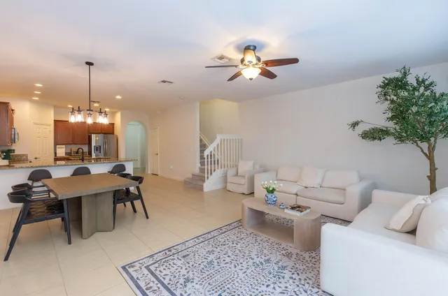 a living room with furniture a chandelier and a rug
