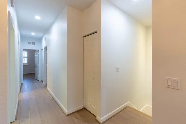 a view of a hallway with wooden floor