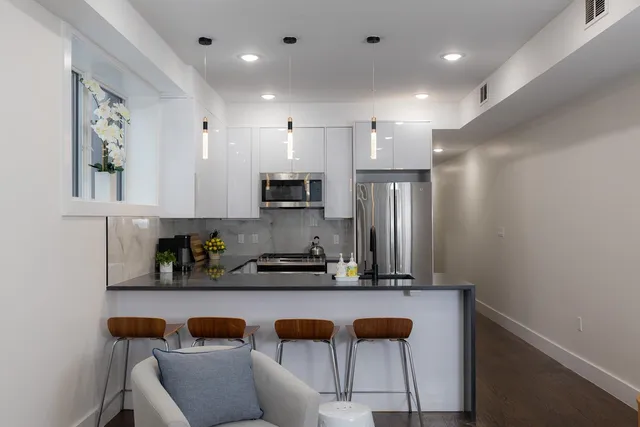 a kitchen with stainless steel appliances granite countertop a refrigerator and a sink