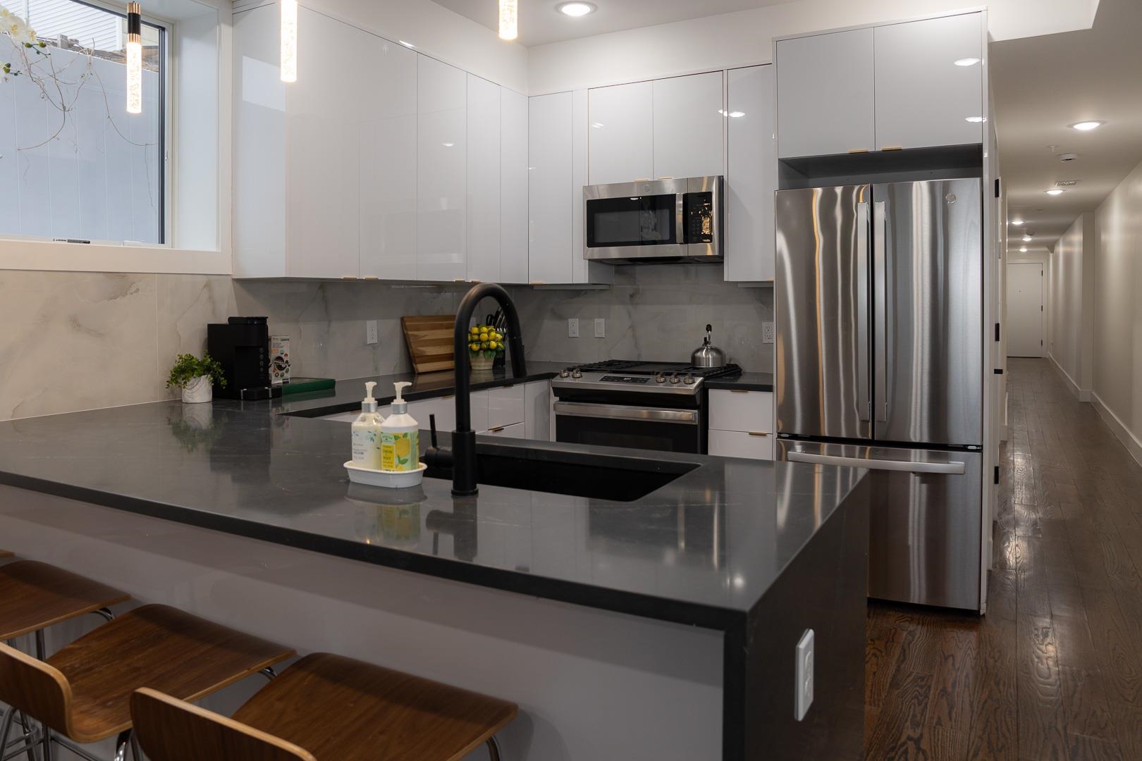 39 Boyd Avenue Jersey City, NJ 07304 - Photo 2 of 29 a kitchen with stainless steel appliances granite countertop a refrigerator a sink a stove and cabinets
