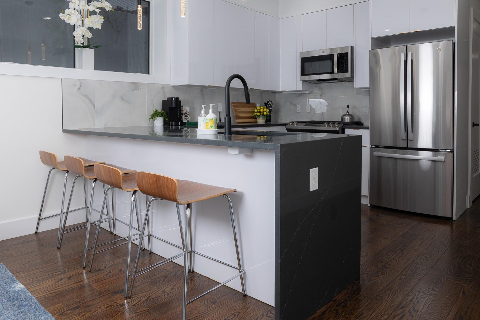 39 Boyd Avenue Jersey City, NJ 07304 - Photo 4 of 29 a kitchen with stainless steel appliances granite countertop a refrigerator a stove a sink with wooden floors and cabinets