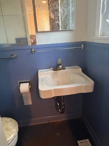 a bathroom with a sink a toilet and a window